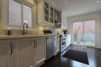 Example of a large minimalist galley dark wood floor eat-in kitchen design in Toronto with an undermount sink, recessed-panel cabinets, white cabinets, quartzite countertops, white backsplash, stone tile backsplash, an island and stainless steel appliances