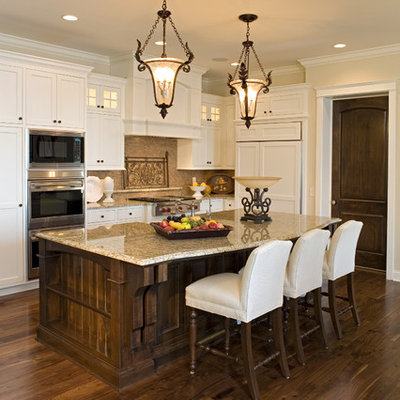 Example of a classic kitchen design in Minneapolis with recessed-panel cabinets, white cabinets, beige backsplash and paneled appliances