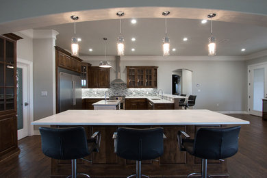 Large transitional u-shaped porcelain tile eat-in kitchen photo in Dallas with an undermount sink, raised-panel cabinets, medium tone wood cabinets, quartz countertops, gray backsplash, mosaic tile backsplash, stainless steel appliances and two islands