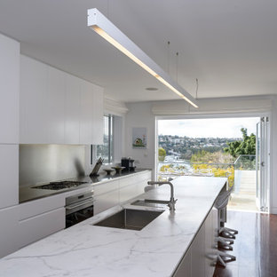Inspiration for a contemporary galley kitchen in Sydney with an undermount sink, metallic splashback, stainless steel appliances, dark hardwood floors, with island, brown floor, white benchtop, flat-panel cabinets, white cabinets and metal splashback.