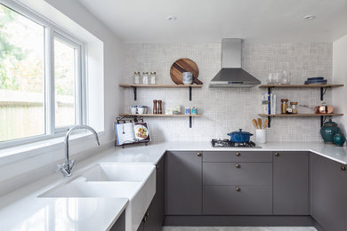 Small scandi u-shaped enclosed kitchen in Buckinghamshire with a belfast sink, flat-panel cabinets, grey cabinets, quartz worktops and white splashback.