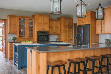 Kitchen - transitional u-shaped dark wood floor and brown floor kitchen idea in Other with medium tone wood cabinets, an island, a farmhouse sink, shaker cabinets, gray backsplash, stainless steel appliances and gray countertops