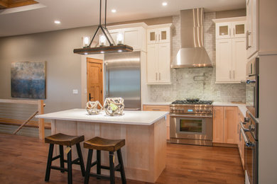 Example of a l-shaped open concept kitchen design in Other with shaker cabinets, light wood cabinets and an island