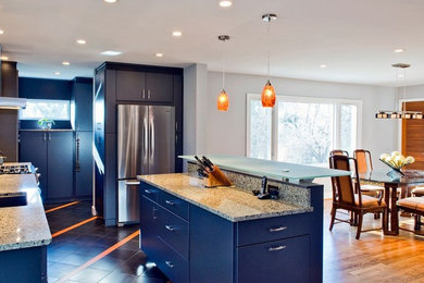 Example of a mid-sized transitional l-shaped medium tone wood floor and brown floor eat-in kitchen design in Orange County with an undermount sink, flat-panel cabinets, blue cabinets, granite countertops, beige backsplash, stainless steel appliances and an island