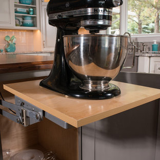 Immagine di un'ampia cucina shabby-chic style con lavello stile country, ante con bugna sagomata, ante con finitura invecchiata, top in granito, paraspruzzi grigio, paraspruzzi con piastrelle in terracotta, elettrodomestici in acciaio inossidabile, parquet scuro e 2 o più isole