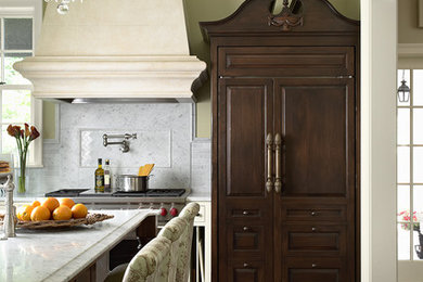 Kitchen - traditional kitchen idea in Minneapolis with raised-panel cabinets, dark wood cabinets, white backsplash, paneled appliances and marble backsplash