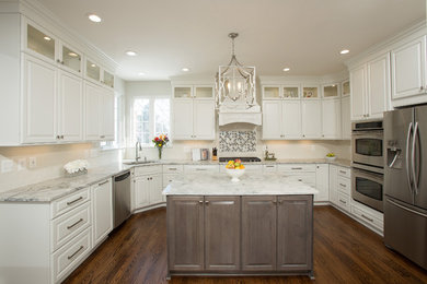 Example of a large transitional u-shaped eat-in kitchen design in DC Metro with granite countertops, stainless steel appliances and two islands