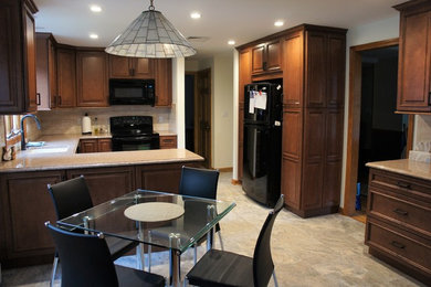 Example of a mid-sized classic u-shaped ceramic tile and multicolored floor eat-in kitchen design in Bridgeport with a single-bowl sink, raised-panel cabinets, dark wood cabinets, quartz countertops, beige backsplash, ceramic backsplash, black appliances and a peninsula