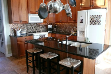 Inspiration for a mid-sized timeless l-shaped ceramic tile and beige floor kitchen remodel in Philadelphia with a double-bowl sink, brown cabinets, multicolored backsplash, white appliances and an island