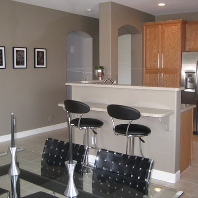 Example of a mid-sized trendy l-shaped ceramic tile and beige floor open concept kitchen design in Phoenix with an undermount sink, recessed-panel cabinets, solid surface countertops, multicolored backsplash, glass sheet backsplash, stainless steel appliances, light wood cabinets, an island and beige countertops