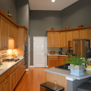 Large transitional open concept kitchen photos - Example of a large transitional u-shaped medium tone wood floor open concept kitchen design in DC Metro with a double-bowl sink, raised-panel cabinets, light wood cabinets, solid surface countertops, beige backsplash, porcelain backsplash, stainless steel appliances and an island