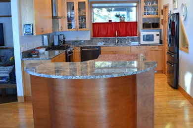 Large trendy u-shaped enclosed kitchen photo in Other with a double-bowl sink, flat-panel cabinets, medium tone wood cabinets, granite countertops, black appliances and an island