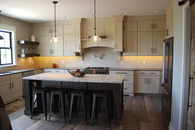Inspiration for an u-shaped kitchen in Grand Rapids with a submerged sink, dark wood cabinets, engineered stone countertops, stainless steel appliances and an island.