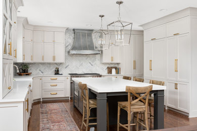 Foto på ett stort vintage vit kök, med en rustik diskho, skåp i shakerstil, vita skåp, bänkskiva i kvartsit, grått stänkskydd, stänkskydd i marmor, rostfria vitvaror, mörkt trägolv, en köksö och brunt golv