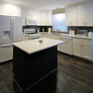 Kitchen - White cabinetry and appliances, gray island, granite counter top and d