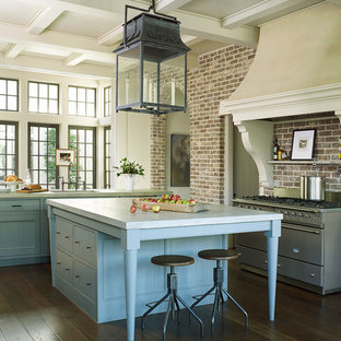 This is an example of a large traditional u-shaped eat-in kitchen in Houston with blue cabinets, concrete benchtops, brick splashback, stainless steel appliances, dark hardwood floors, multiple islands, brown floor, an undermount sink, beaded inset cabinets and multi-coloured splashback.
