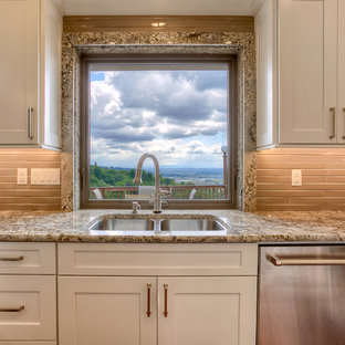 Transitional kitchen designs - Example of a transitional medium tone wood floor kitchen design in Seattle with an undermount sink, shaker cabinets, white cabinets, granite countertops, brown backsplash, stainless steel appliances and a peninsula