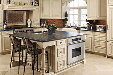Example of a large classic l-shaped ceramic tile eat-in kitchen design in Philadelphia with a farmhouse sink, raised-panel cabinets, white cabinets, granite countertops, red backsplash, stainless steel appliances and an island
