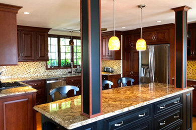 Eat-in kitchen - mid-sized traditional u-shaped dark wood floor and brown floor eat-in kitchen idea in Boston with an undermount sink, raised-panel cabinets, dark wood cabinets, granite countertops, mosaic tile backsplash, stainless steel appliances, an island and multicolored countertops