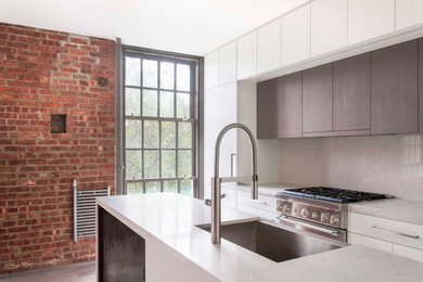 Example of a small urban u-shaped light wood floor and gray floor open concept kitchen design in New York with a single-bowl sink, flat-panel cabinets, white cabinets, quartz countertops, gray backsplash, quartz backsplash, stainless steel appliances, a peninsula and gray countertops