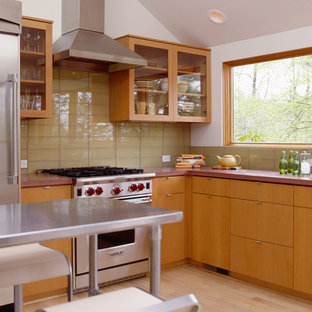 Inspiration for a modern l-shaped kitchen in Portland with glass-front cabinets, medium wood cabinets, concrete benchtops, yellow splashback, glass tile splashback and stainless steel appliances.