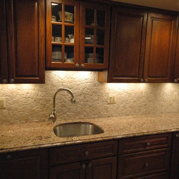 Kitchen with granite countertops and stone backsplash