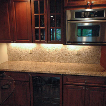 Kitchen with granite countertops and stone backsplash