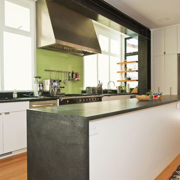 Kitchen with island and back-painted glass and exposed painted moment frame