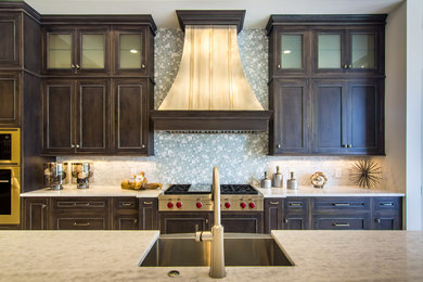 Example of a trendy open concept kitchen design in Orlando with an undermount sink, recessed-panel cabinets, dark wood cabinets, marble countertops, multicolored backsplash, mosaic tile backsplash, stainless steel appliances and an island