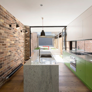 kitchen with New York loft metal door, recycled brick and courtyard beyond.