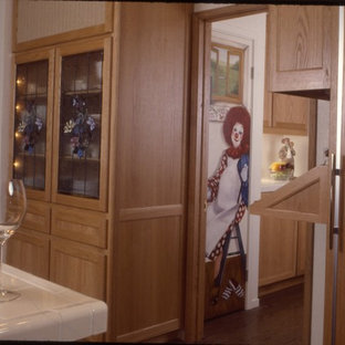 Réalisation d'une grand cuisine américaine bohème en U avec un évier 3 bacs, un placard à porte shaker, des portes de placard en bois clair, un plan de travail en carrelage, une crédence blanche, une crédence en carreau de céramique, un électroménager en acier inoxydable et un sol en bois brun.