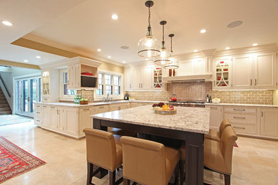 Example of a huge classic u-shaped travertine floor and beige floor enclosed kitchen design in Other with an undermount sink, beaded inset cabinets, white cabinets, granite countertops, beige backsplash, ceramic backsplash, paneled appliances and an island