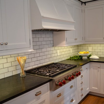 Kitchen with White Cabinets and Stainless Range Set in Black Countertop