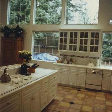 Kitchen with white cabinets, tile floor and tile counters, backsplash