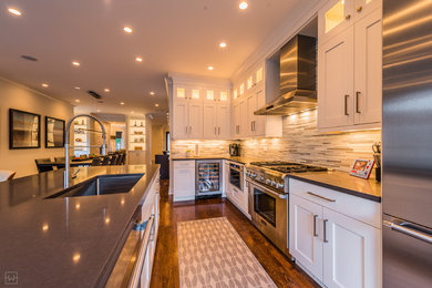 Example of a large minimalist dark wood floor eat-in kitchen design in Chicago with an undermount sink, glass tile backsplash, stainless steel appliances and an island