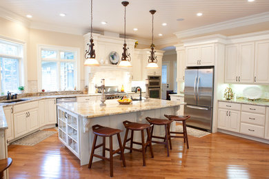 Large elegant medium tone wood floor eat-in kitchen photo in New York with an undermount sink, raised-panel cabinets, white cabinets, granite countertops, stainless steel appliances and an island