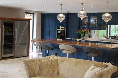 Design ideas for a traditional kitchen in Other with blue cabinets, an island and white worktops.