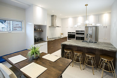 Example of a trendy eat-in kitchen design in Toronto with flat-panel cabinets, white cabinets, stainless steel appliances and an island