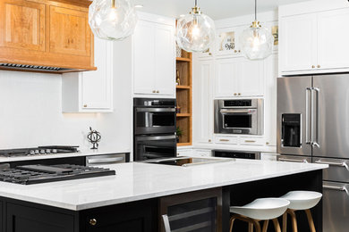 Inspiration for a transitional l-shaped kitchen remodel in Albuquerque with shaker cabinets, white cabinets, white backsplash, stainless steel appliances, an island and white countertops
