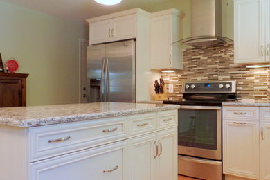 Example of a mid-sized trendy l-shaped light wood floor eat-in kitchen design in Cleveland with white cabinets, granite countertops, multicolored backsplash, stainless steel appliances and an island