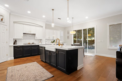 Inspiration for a contemporary brown floor eat-in kitchen remodel in Sacramento with a farmhouse sink, white cabinets, quartz countertops, white backsplash, subway tile backsplash, stainless steel appliances, an island and white countertops