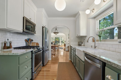 Trendy brown floor eat-in kitchen photo in Sacramento with a farmhouse sink, green cabinets, granite countertops, white backsplash, ceramic backsplash, stainless steel appliances, no island and beige countertops