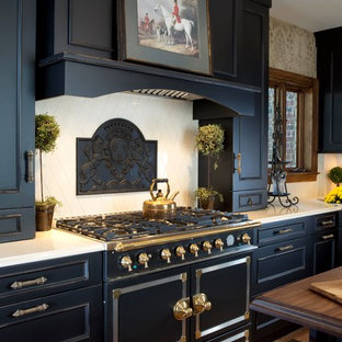 This is an example of a large traditional u-shaped eat-in kitchen in New York with recessed-panel cabinets, black cabinets, beige splashback, black appliances, medium hardwood floors and with island.