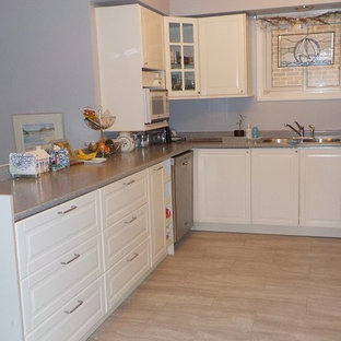Photo of a mid-sized modern u-shaped separate kitchen in Toronto with a double-bowl sink, shaker cabinets, white cabinets, laminate benchtops, stainless steel appliances, vinyl floors and a peninsula.