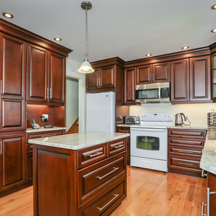 This is an example of a mid-sized traditional u-shaped eat-in kitchen in Toronto with a double-bowl sink, raised-panel cabinets, medium wood cabinets, quartzite benchtops, light hardwood floors and with island.