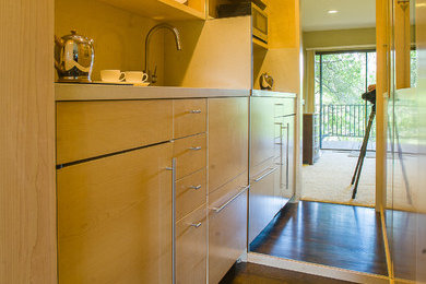 サンフランシスコにある高級な小さなコンテンポラリースタイルのおしゃれなキッチン (オープンシェルフ、淡色木目調キャビネット、クオーツストーンカウンター、パネルと同色の調理設備、アイランドなし) の写真