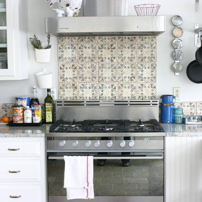 Inspiration for an eclectic kitchen remodel in Chicago with white cabinets, multicolored backsplash and stainless steel appliances