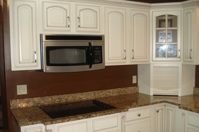 Ejemplo de cocina tradicional grande con puertas de armario blancas, salpicadero marrón y electrodomésticos de acero inoxidable
