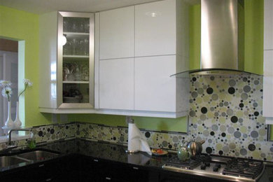 Mid-sized l-shaped kitchen pantry photo in Baltimore with a double-bowl sink, flat-panel cabinets, white cabinets, solid surface countertops and multicolored backsplash