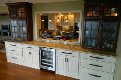 Large elegant medium tone wood floor kitchen photo in Other with white cabinets and marble countertops